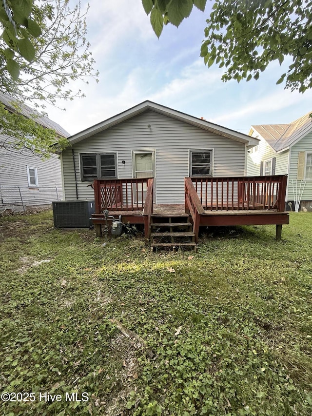 rear view of house featuring a lawn, a wooden deck, and central AC unit