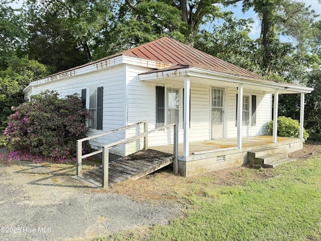 view of front of home with a porch, a standing seam roof, and metal roof