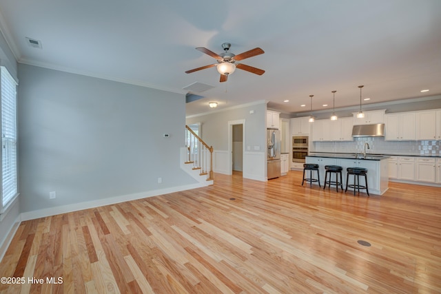 1012 Anchors Bend Way, Wilmington, NC 28411 - unfurnished living room featuring a wealth of natural light, crown molding, a ceiling fan, and a sink