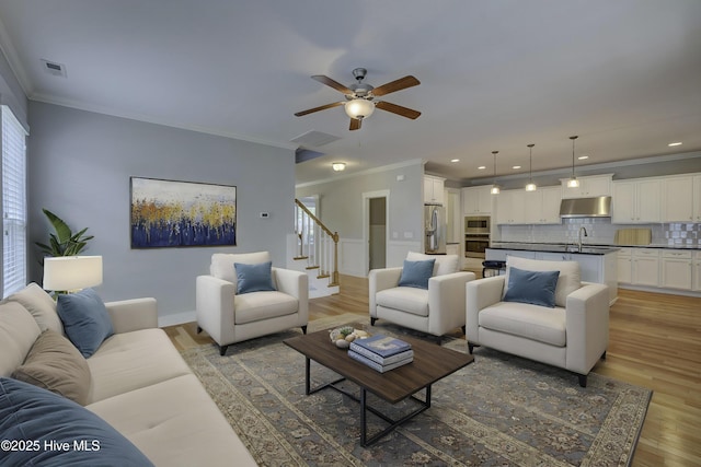 1012 Anchors Bend Way, Wilmington, NC 28411 - living room featuring light wood-style floors, ceiling fan, crown molding, stairs, and visible vents