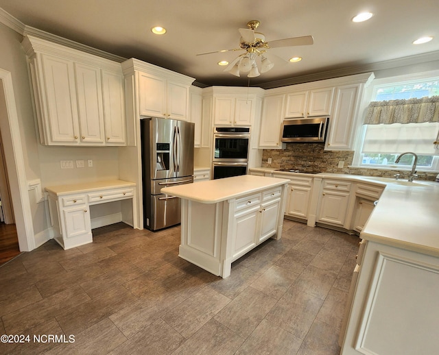 kitchen with a ceiling fan, appliances with stainless steel finishes, light countertops, a sink, and ornamental molding