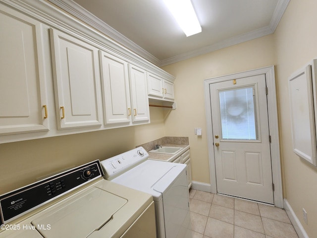 washroom featuring ornamental molding, washer and dryer, baseboards, cabinet space, and light tile patterned floors