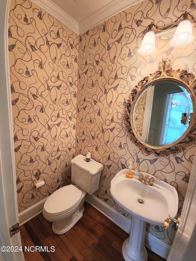 bathroom with crown molding, baseboards, wood finished floors, and wallpapered walls