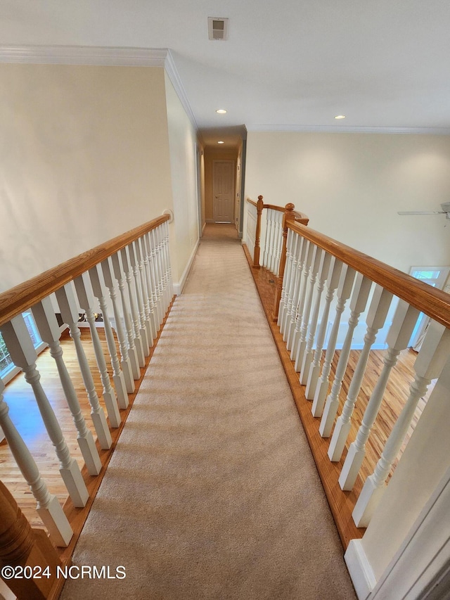 hall featuring light colored carpet, recessed lighting, baseboards, visible vents, and ornamental molding