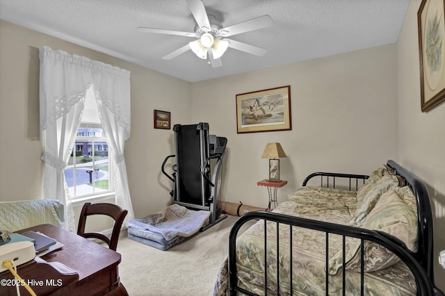 carpeted bedroom featuring a textured ceiling and ceiling fan