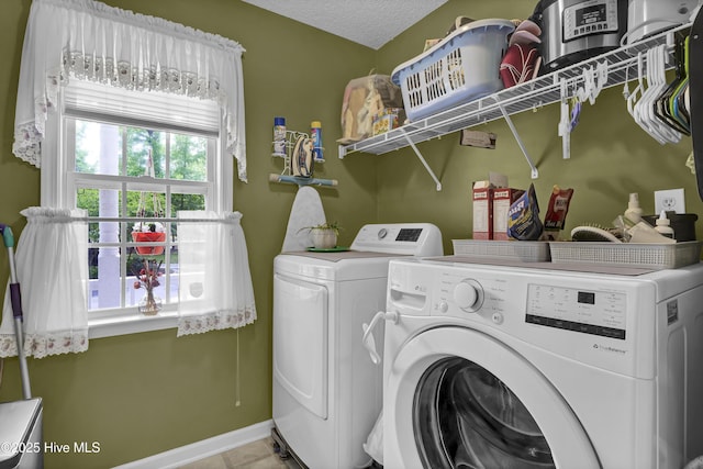 laundry room with washer and clothes dryer, tile patterned flooring, baseboards, and a textured ceiling