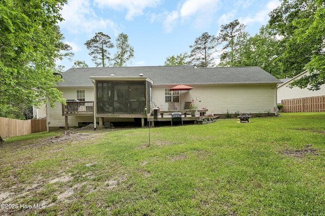 back of house featuring a sunroom, a wooden deck, a fire pit, and roof with shingles