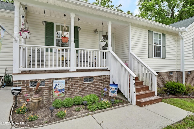 entrance to property featuring crawl space and covered porch