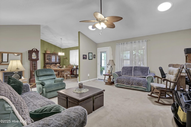 living area with ceiling fan, a chandelier, carpet floors, lofted ceiling, and baseboards