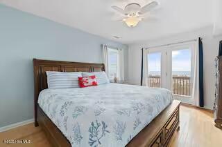 bedroom featuring baseboards, access to exterior, and light wood-style floors