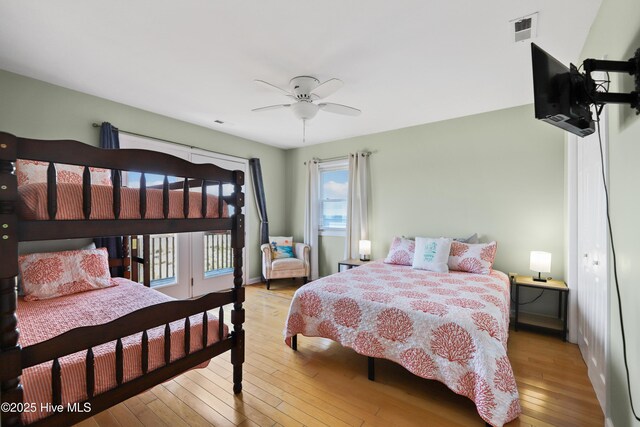 bedroom featuring visible vents, wood finished floors, access to exterior, baseboards, and ceiling fan