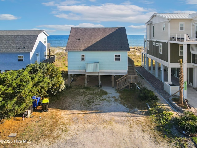 exterior space featuring stairs, a water view, and central AC