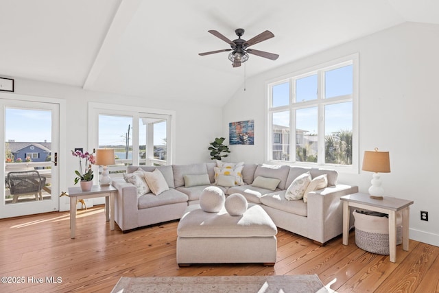 living room with light wood-style floors, a ceiling fan, and vaulted ceiling