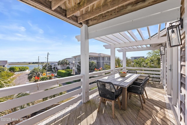 deck featuring a water view, a pergola, and outdoor dining area