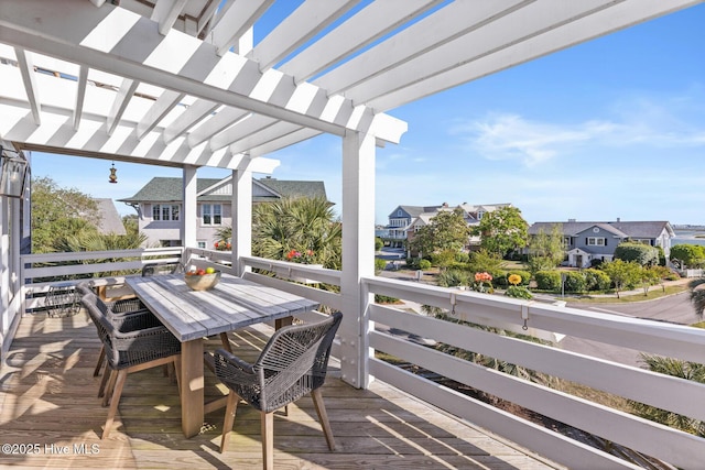 deck featuring a pergola, a residential view, and outdoor dining space