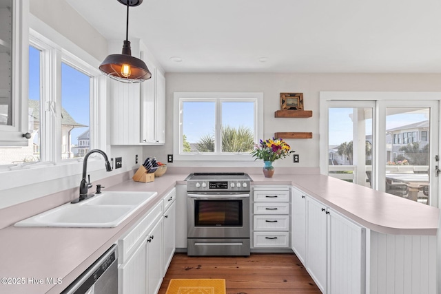 kitchen featuring a sink, appliances with stainless steel finishes, white cabinets, and light countertops