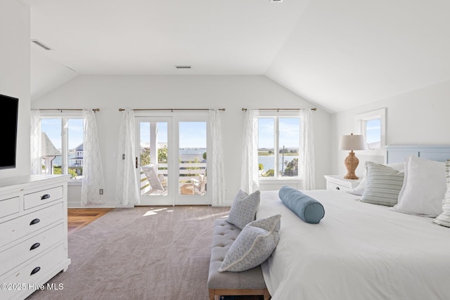 bedroom with access to outside, vaulted ceiling, multiple windows, and visible vents