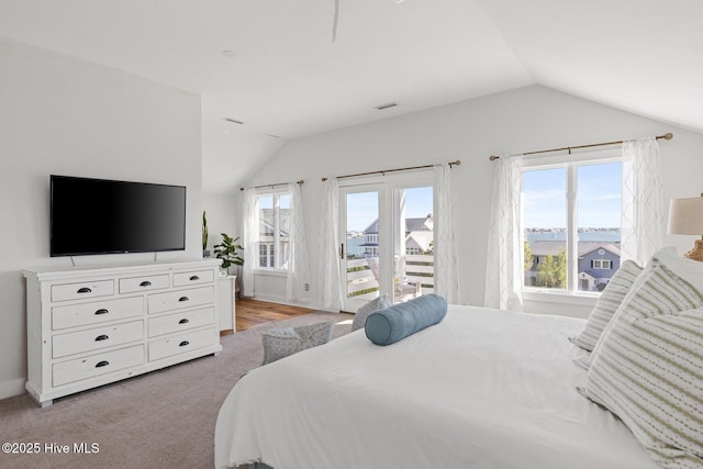 bedroom featuring vaulted ceiling, access to exterior, and visible vents