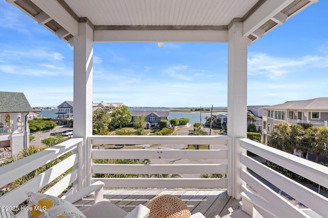 balcony with a residential view and a water view