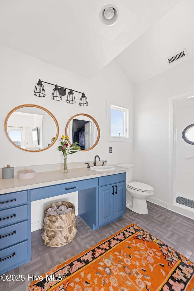 bathroom with visible vents, vaulted ceiling, a shower, vanity, and toilet