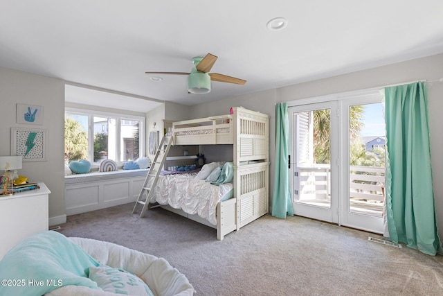 bedroom with carpet, ceiling fan, multiple windows, and access to exterior