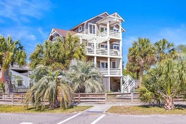 view of front facade featuring fence private yard and a balcony