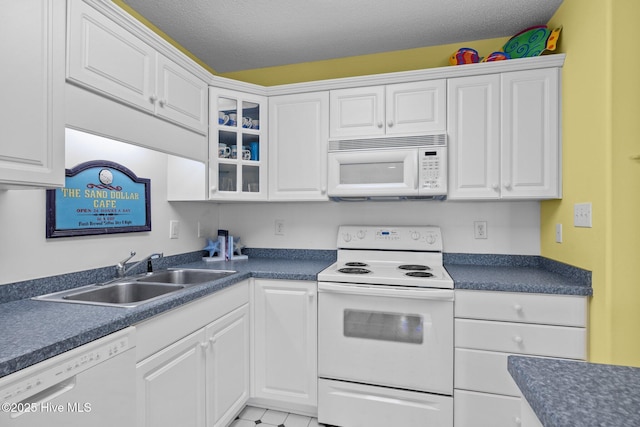 kitchen featuring white cabinetry, white appliances, and a sink