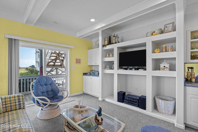 living area with baseboards, built in shelves, and light carpet