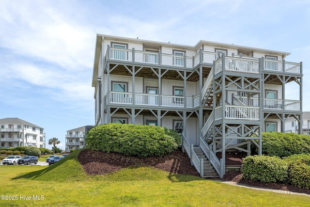 rear view of property with a yard and stairway
