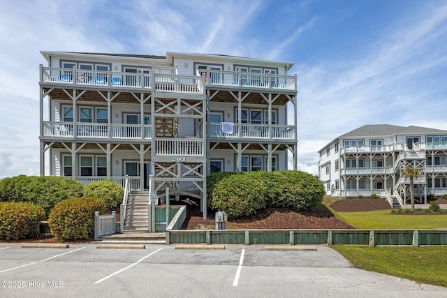 view of property featuring stairway and uncovered parking