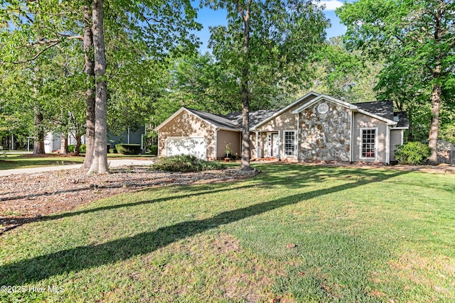 view of front of property featuring an attached garage, a front lawn, and stone siding