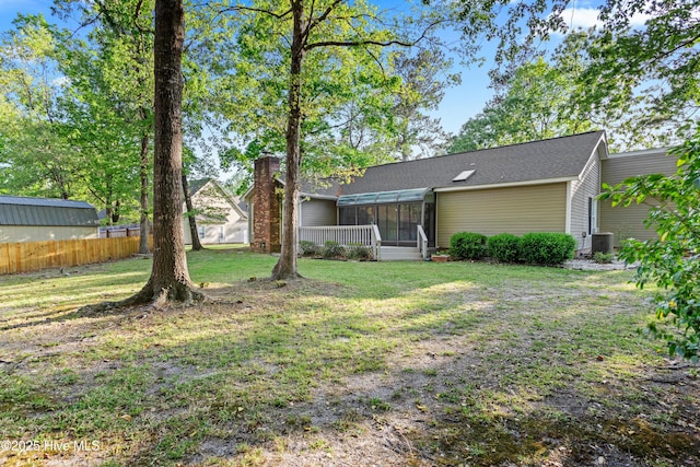 view of yard with cooling unit, a sunroom, and fence