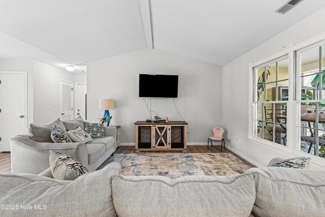 living room featuring visible vents, vaulted ceiling with beams, wood finished floors, and baseboards