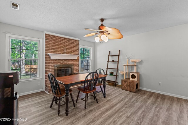 dining area featuring a textured ceiling, wood finished floors, ceiling fan, and baseboards