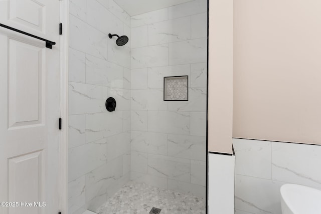 full bath featuring a freestanding tub and marble finish floor