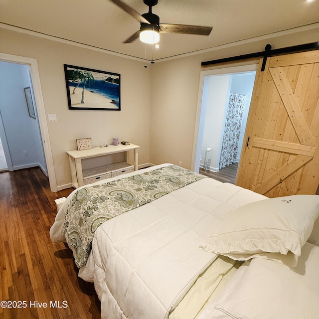 bedroom featuring baseboards, wood finished floors, ceiling fan, and a barn door