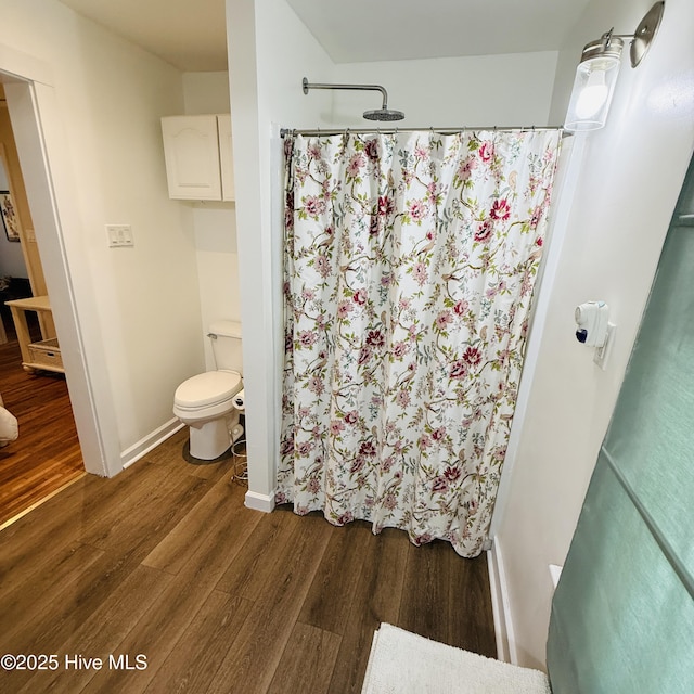 full bathroom featuring toilet, a shower with curtain, wood finished floors, and baseboards