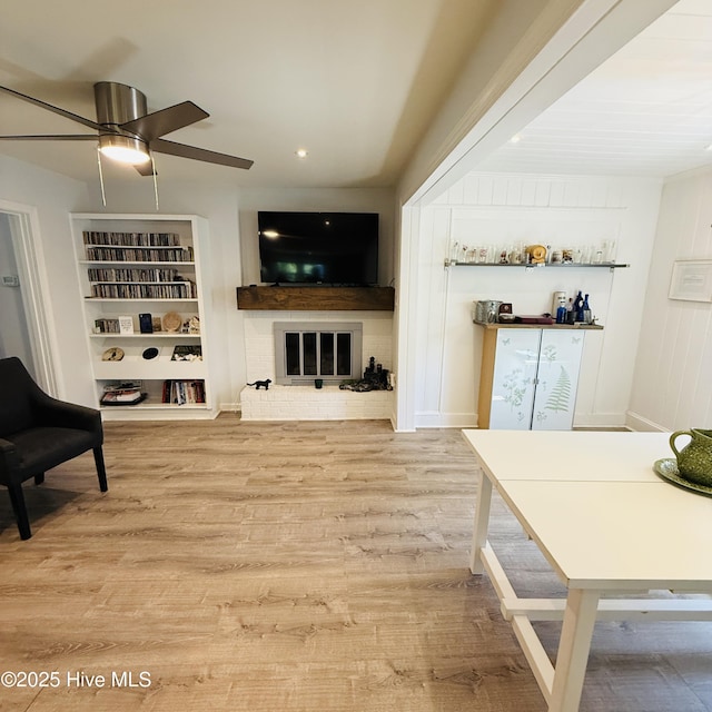living room featuring ceiling fan, a brick fireplace, wood finished floors, and recessed lighting
