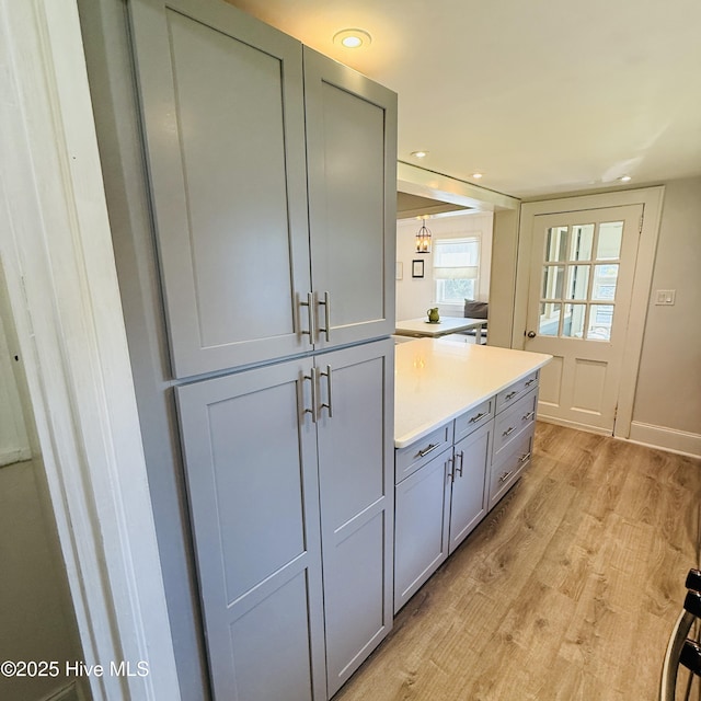 kitchen with light wood-style floors, gray cabinets, light countertops, baseboards, and recessed lighting