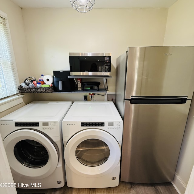laundry room with separate washer and dryer and wood finished floors