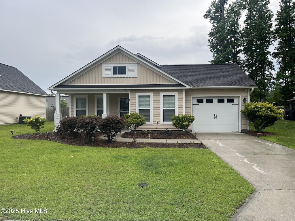 1202 Mill Creek Loop, Leland, NC 28451 - view of front of house featuring a garage, board and batten siding, concrete driveway, a front lawn, and a shingled roof