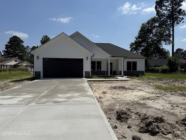 1104 Margaret Ln, Kinston, NC 28501 - modern farmhouse with concrete driveway, an attached garage, stone siding, and board and batten siding
