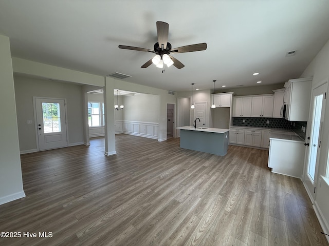 1104 Margaret Ln, Kinston, NC 28501 - kitchen featuring open floor plan, ceiling fan, an island with sink, backsplash, and white cabinets