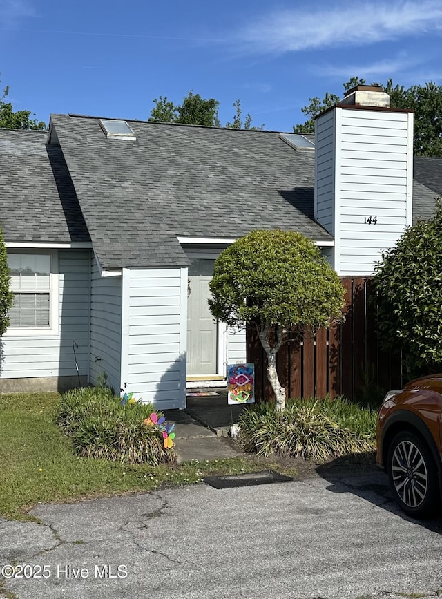 multi unit property featuring fence and roof with shingles