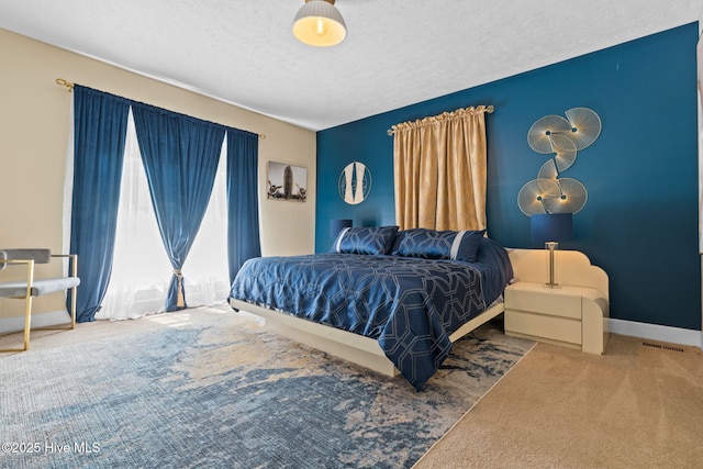 bedroom featuring carpet, baseboards, and a textured ceiling