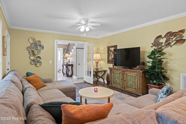 living area featuring ornamental molding, ceiling fan, baseboards, and visible vents