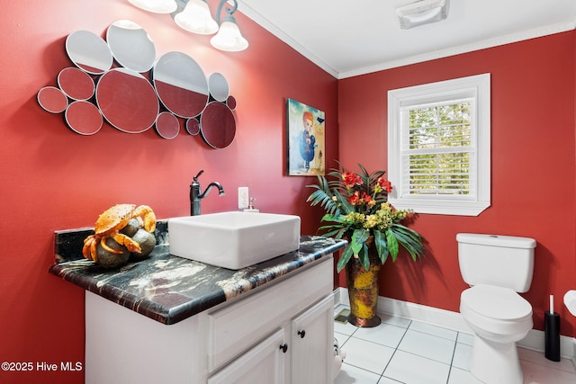 bathroom with vanity, toilet, baseboards, ornamental molding, and tile patterned flooring