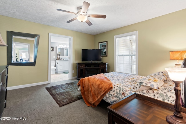 bedroom featuring a textured ceiling, ensuite bathroom, baseboards, and carpet floors
