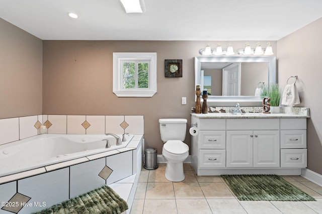 bathroom with vanity, toilet, baseboards, a garden tub, and tile patterned flooring
