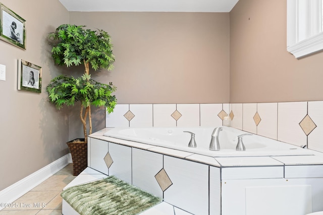 bathroom with a garden tub, tile patterned floors, and baseboards